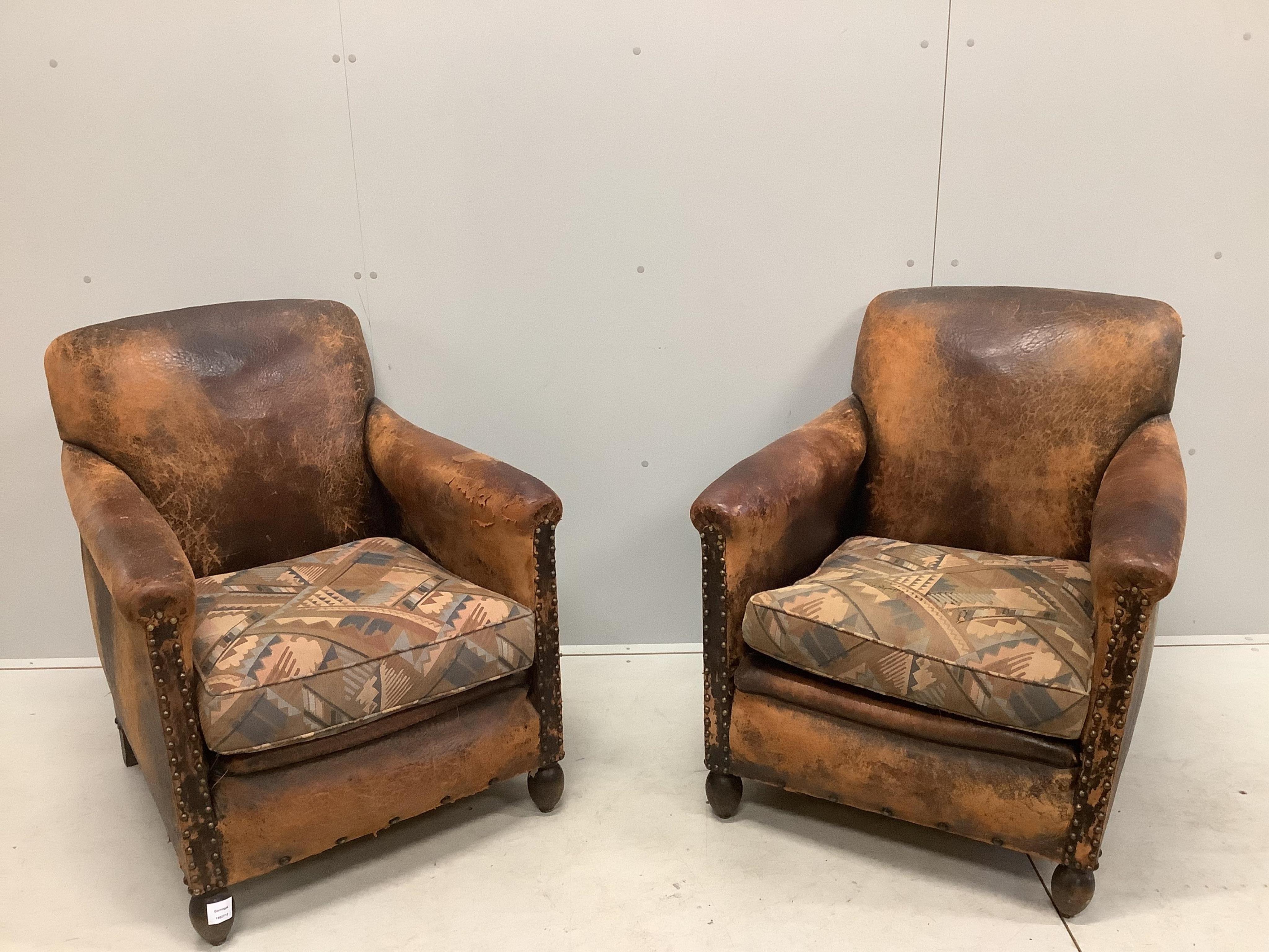 A pair of early 20th century French leather club armchairs, width 73cm, depth 74cm, height 83cm. Condition - poor to fair